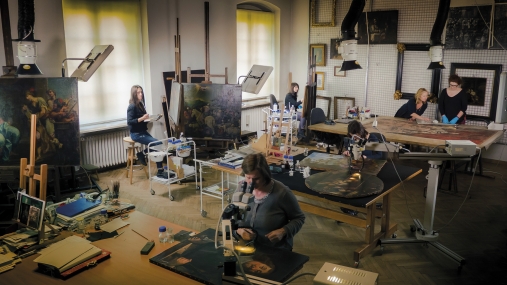 w pracowni konseracji malarstwa, stoły z rozłożonymi obrazami i narzędziami konserwatorskimi